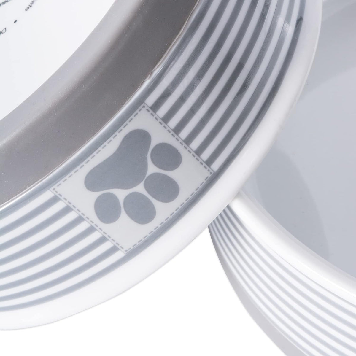 Close-up of striped ceramic pet bowl with paw-print badge and gray removable base