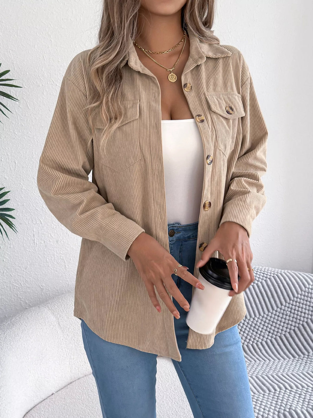 Khaki corduroy shacket with long sleeves, button front, and two chest flap pockets.