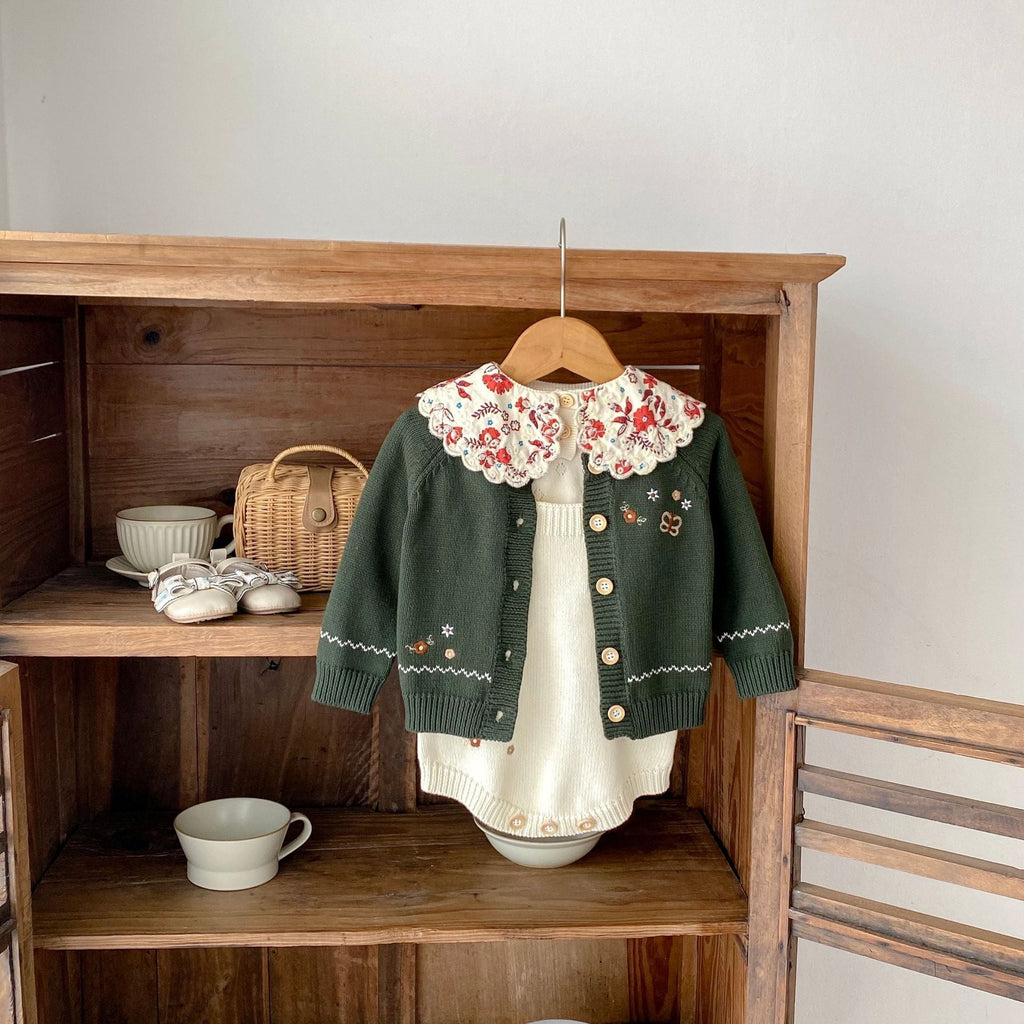 Infant dark green cardigan with red floral collar and contrast hem over cream knit romper