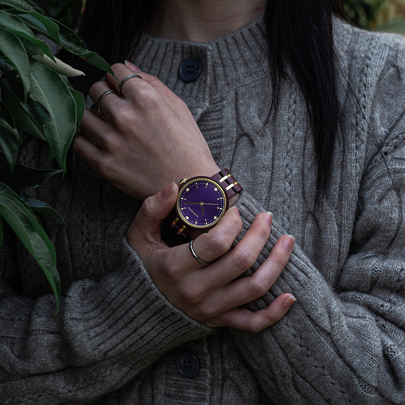 Womens quartz watch with purple dial and gold hands on dark red/burgundy link band
