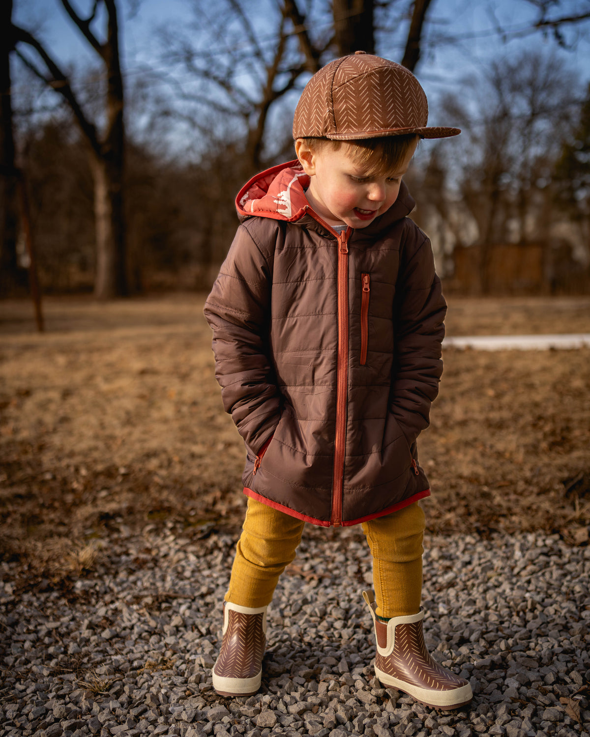 Kids reversible puffy jacket with brown hood and orange piping, quilted front zipper