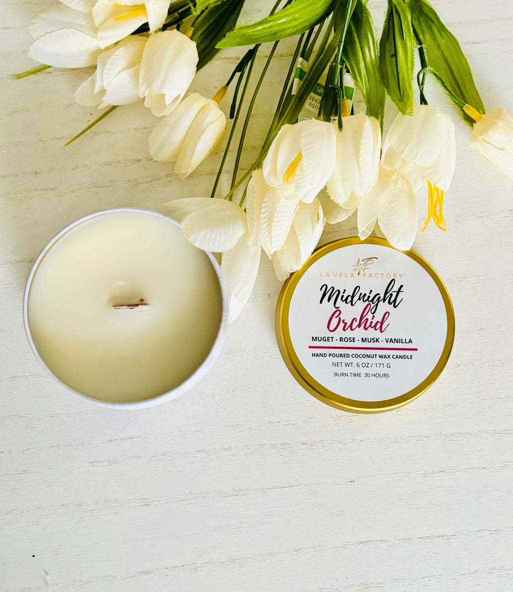 Wood-wick candle in pale green wax; gold lid labeled Midnight Orchid.