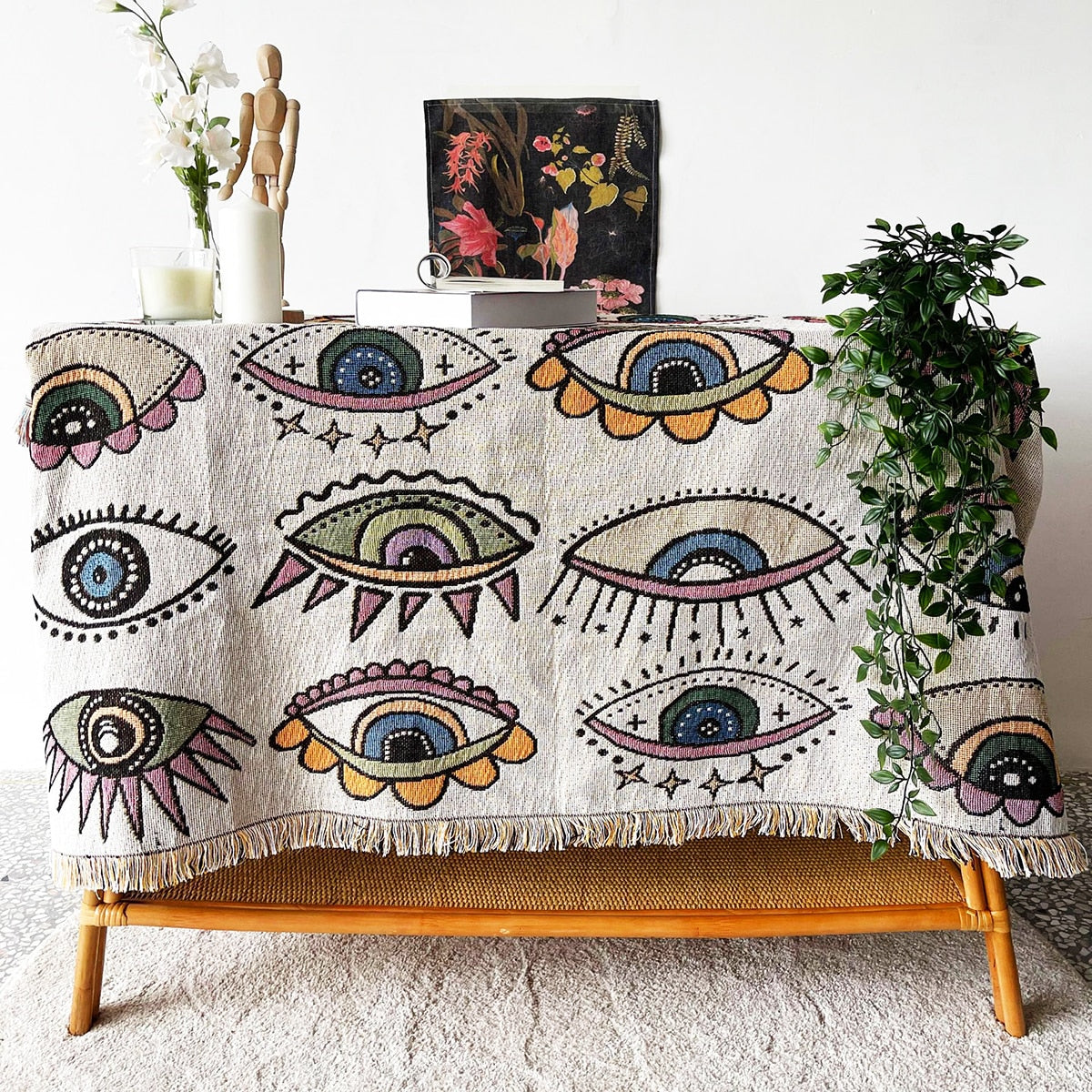 Multicolor evil eye beach blanket with scattered eye motifs and fringed hem