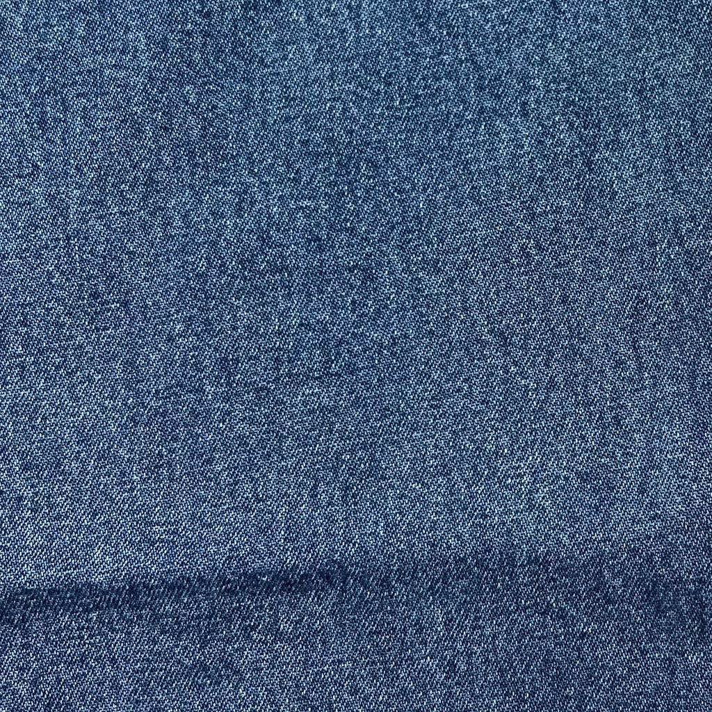Stonewashed indigo blue denim fabric texture swatch for carpenter jeans.