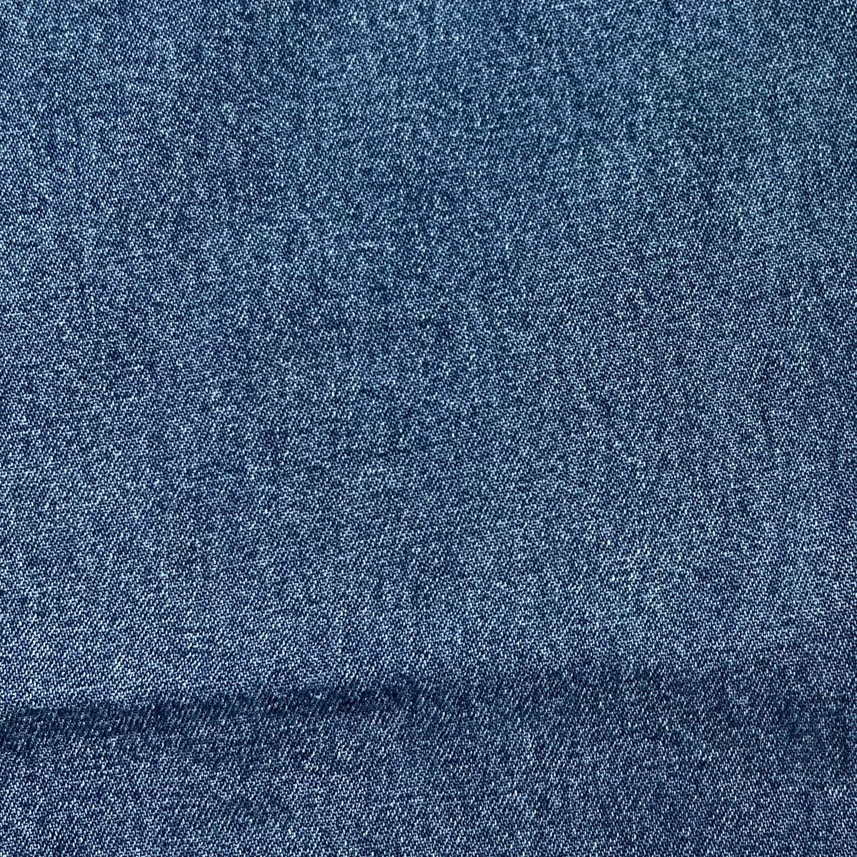 Stonewashed indigo blue denim fabric texture swatch for carpenter jeans.