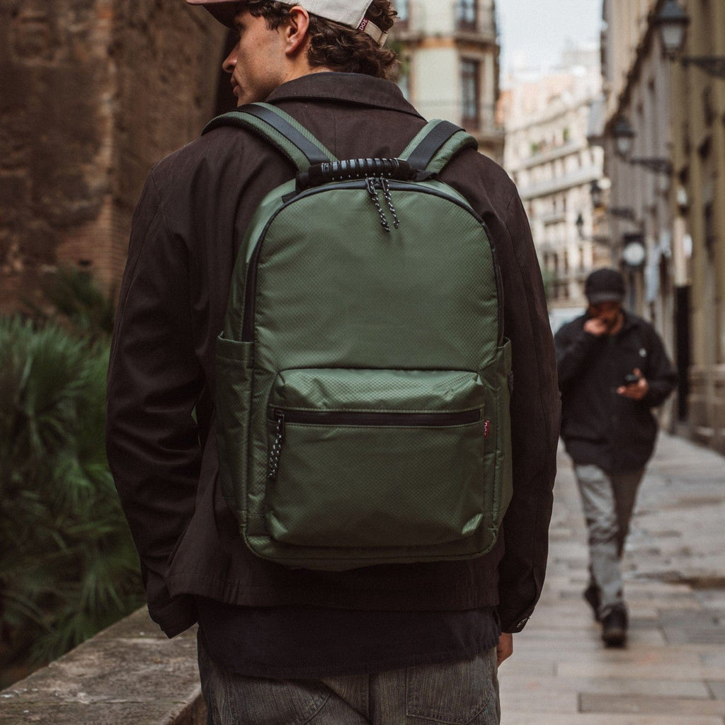 Green backpack with front pocket and shoulder straps, chain zipper pulls.