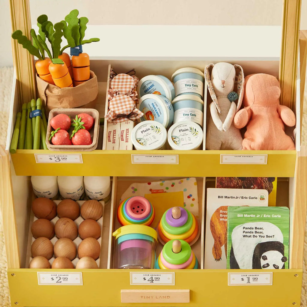 Tiny Land® playset shelf close-up with pretend groceries, cups, and stuffed toy