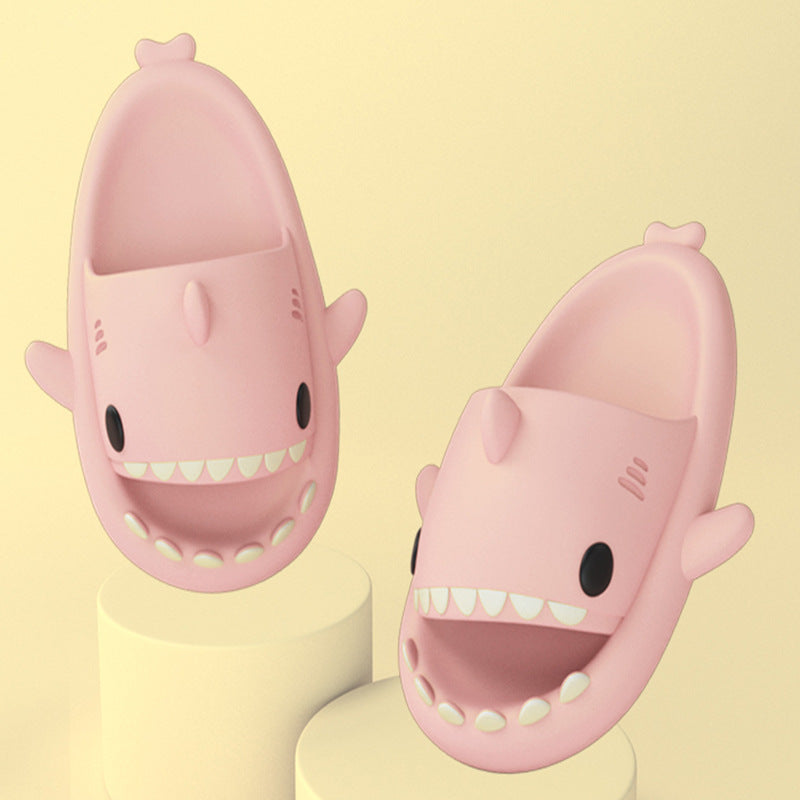 Pink shark-shaped slide sandals on pedestal bases, open toe with white teeth trim