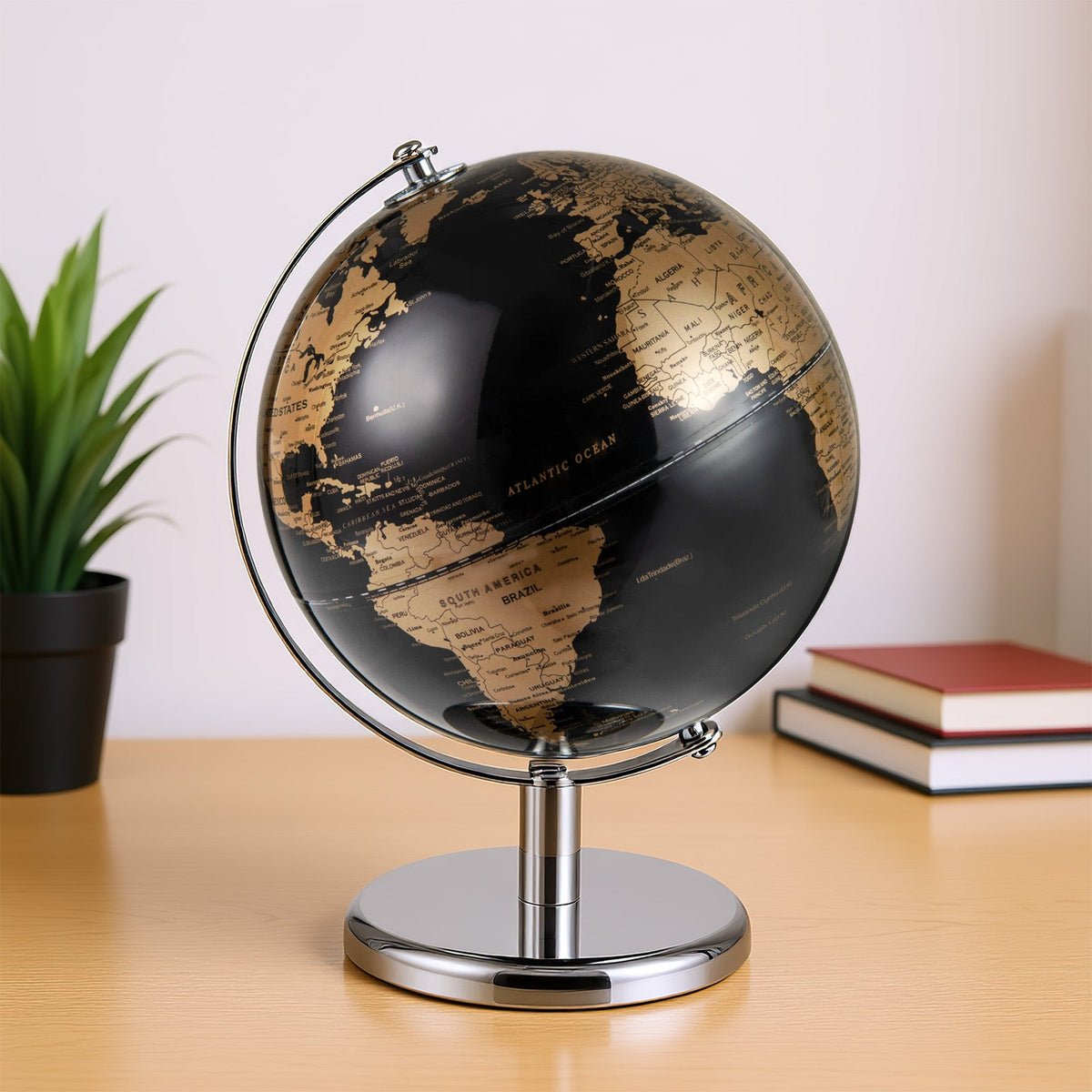 Tabletop decorative earth globe with black oceans, gold continents, and chrome stand.