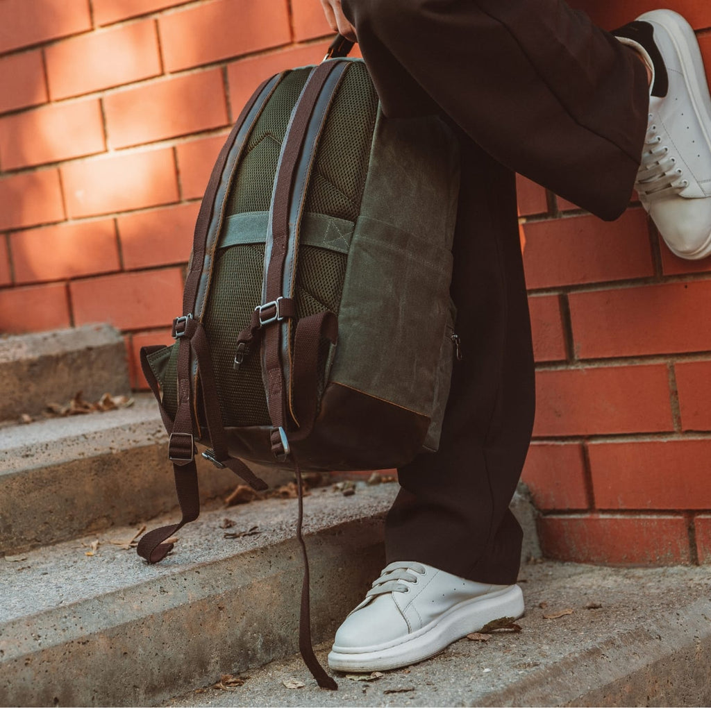 Olive green backpack with wide shoulder straps and front zip pocket