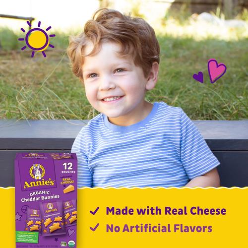 Annie's Organic Cheddar Bunnies 12 pouches box held beside a child