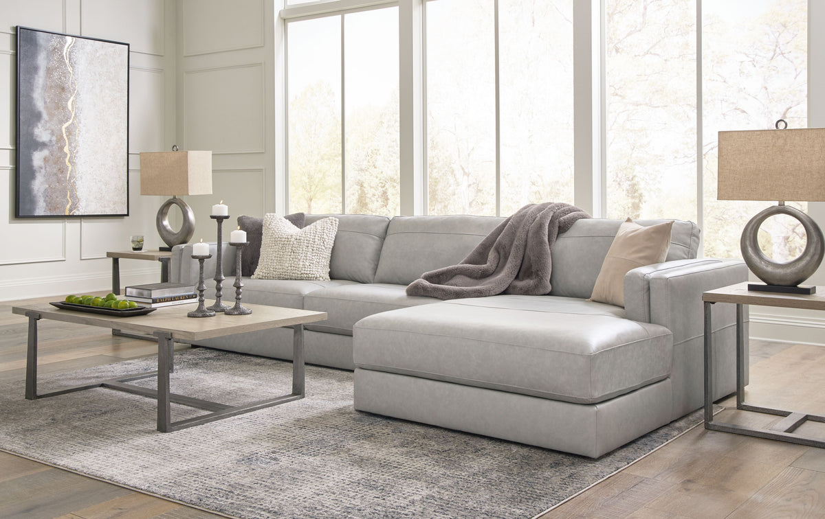 Light gray sectional sofa with corner chaise, layered seat cushions, and arm details