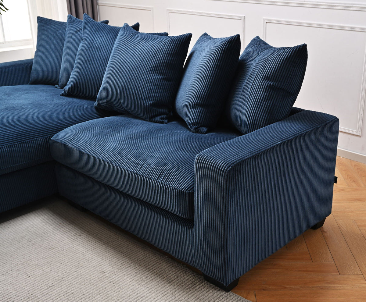 L-shaped sectional sofa with chaise, dark blue corded upholstery and accent pillows