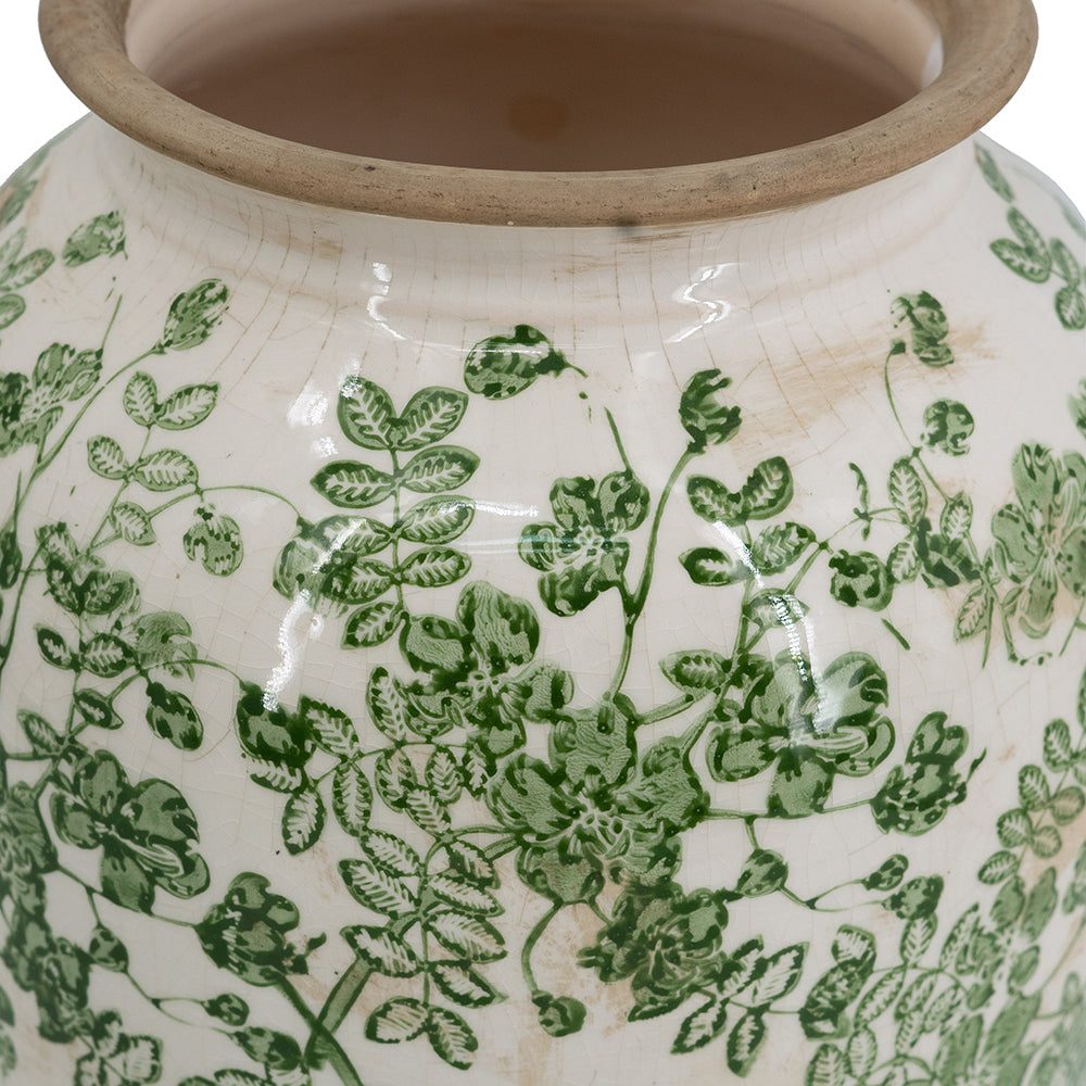 Ceramic vase rim and body close-up with green leafy floral design