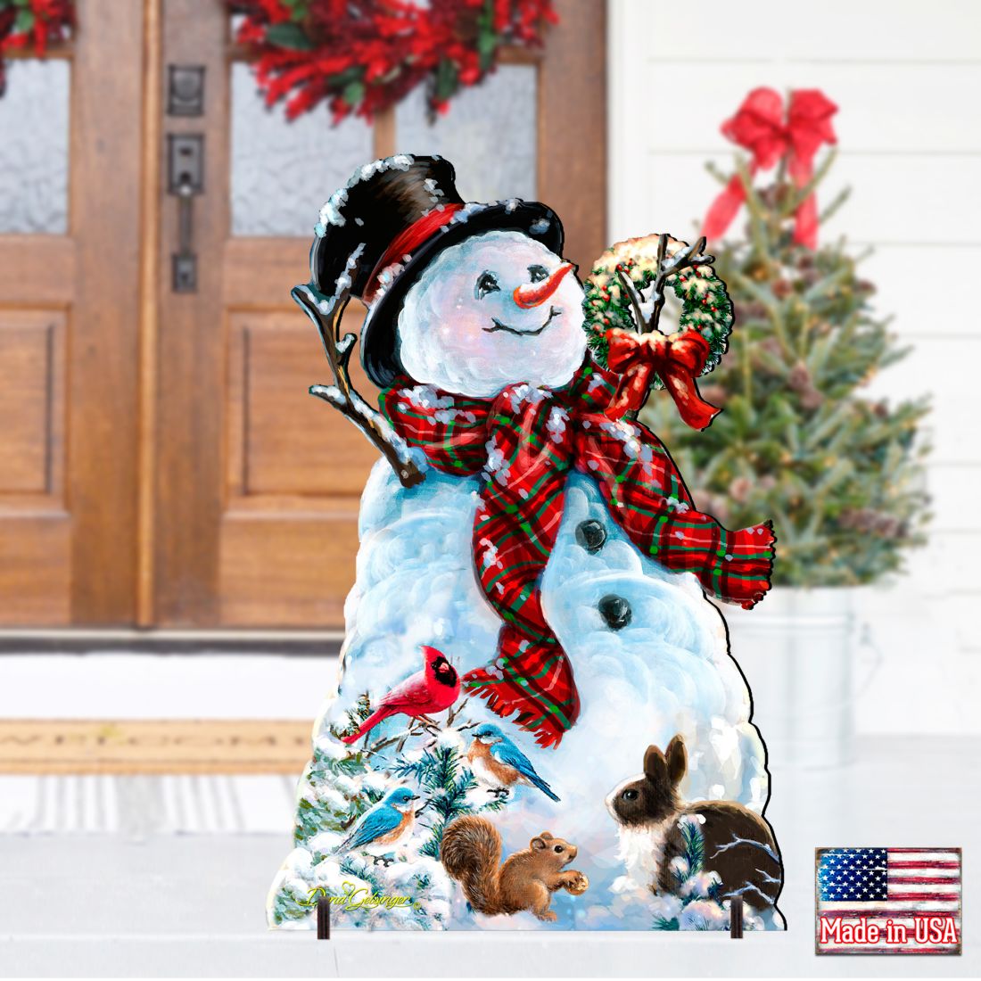 Christmas yard sign with snowman holding wreath and red bow, birds and small animals