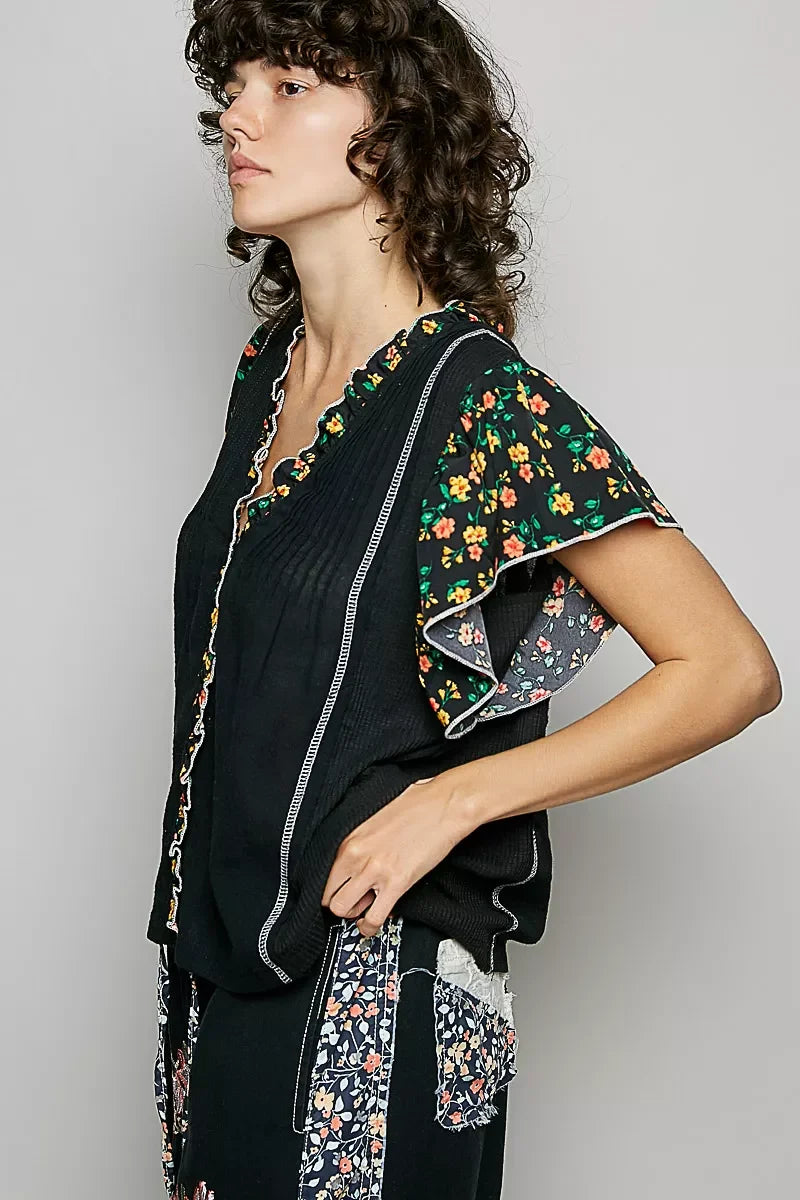 Black V-neck floral blouse with flutter ruffle sleeves and side vertical trim detail