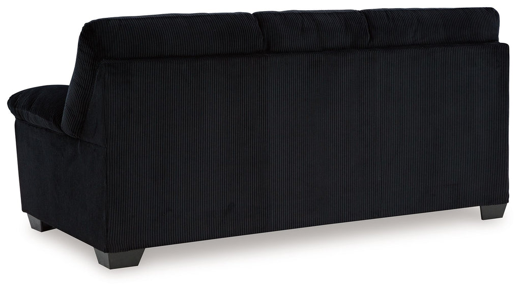 Upholstered sofa in dark fabric, angled back view with boxed back and arm details