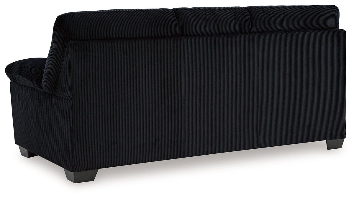 Upholstered sofa in dark fabric, angled back view with boxed back and arm details