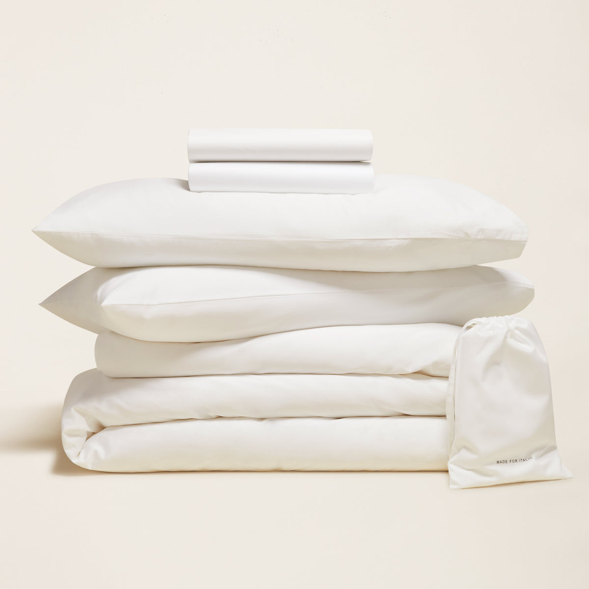White sateen bedding bundle with stacked duvet and pillow set on a clean background