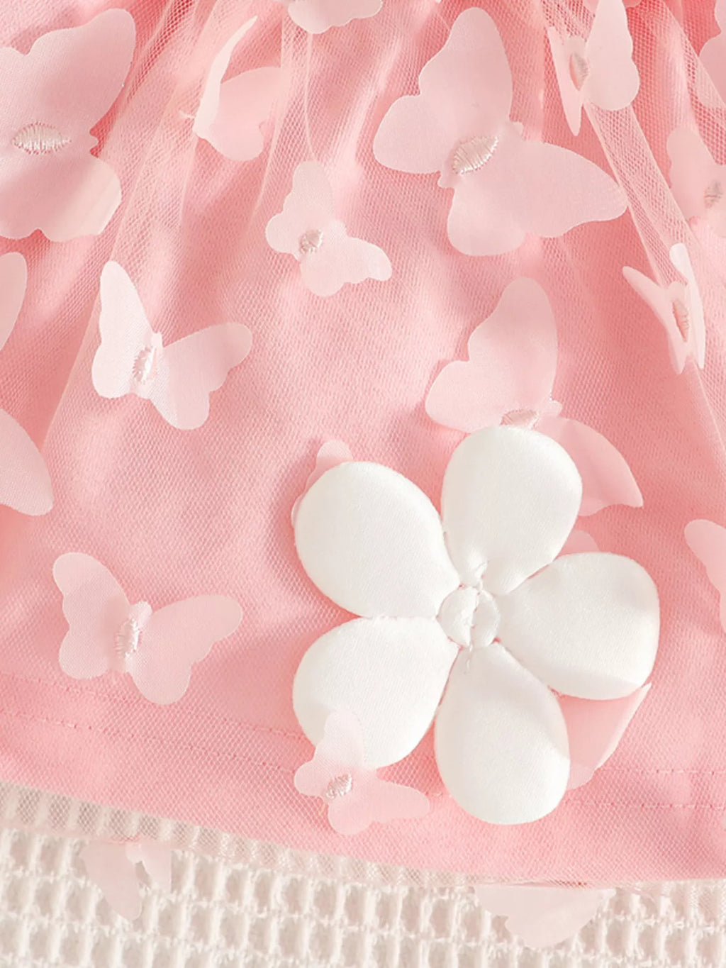 Pink mesh dress with white flower appliques and butterfly-like layered detail