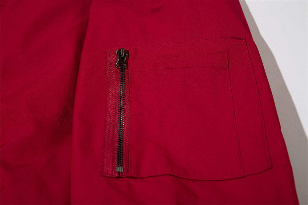 Red jacket coat close-up: zip pocket and stitched chest panel