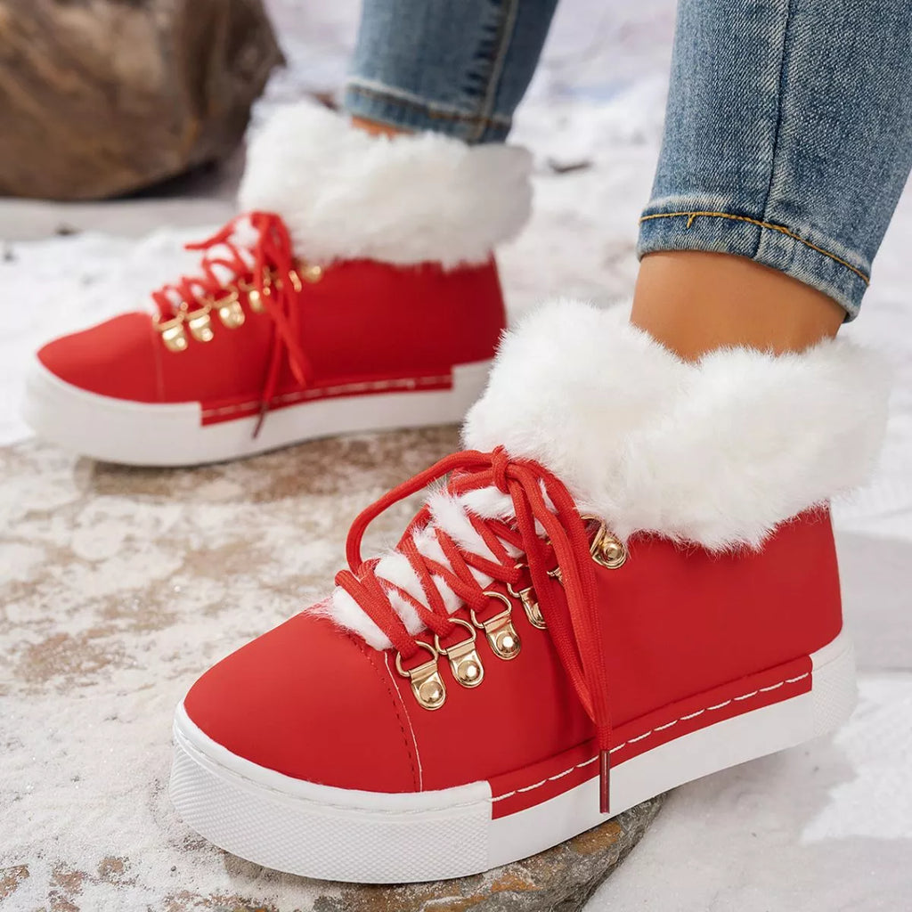 Red lace-up ankle boots with white fuzzy trim and gold charm details