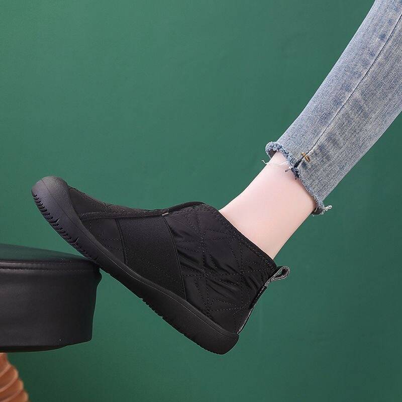 Black ankle snow boots with quilted upper, fleece lining, and flat tread sole