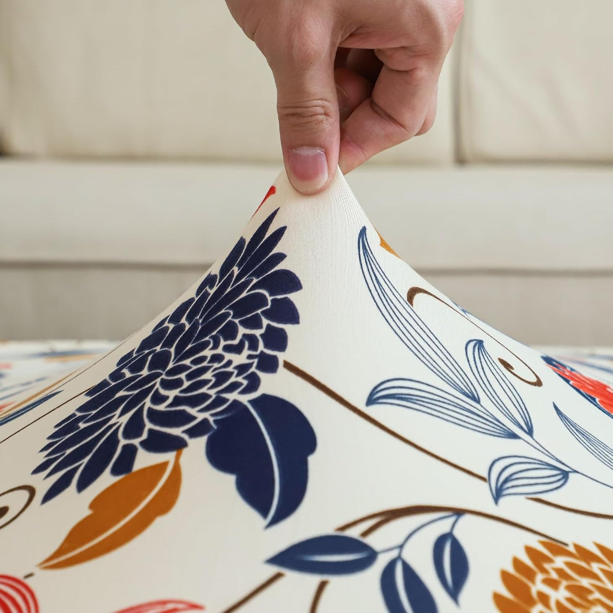 Close-up of white floral chair cover fabric with elastic edge pulled by hand