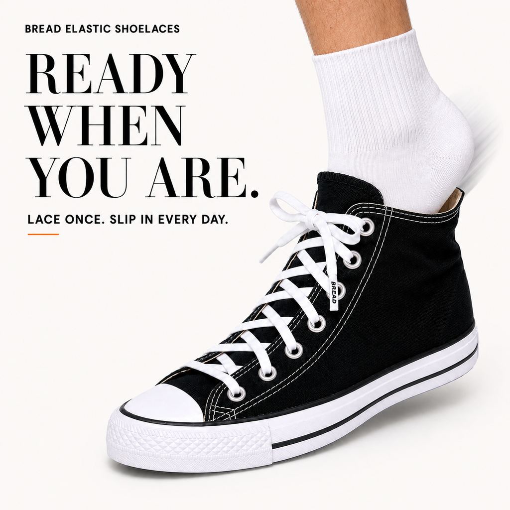 White elastic shoelaces laced on black high-top shoe, ankle view with sock