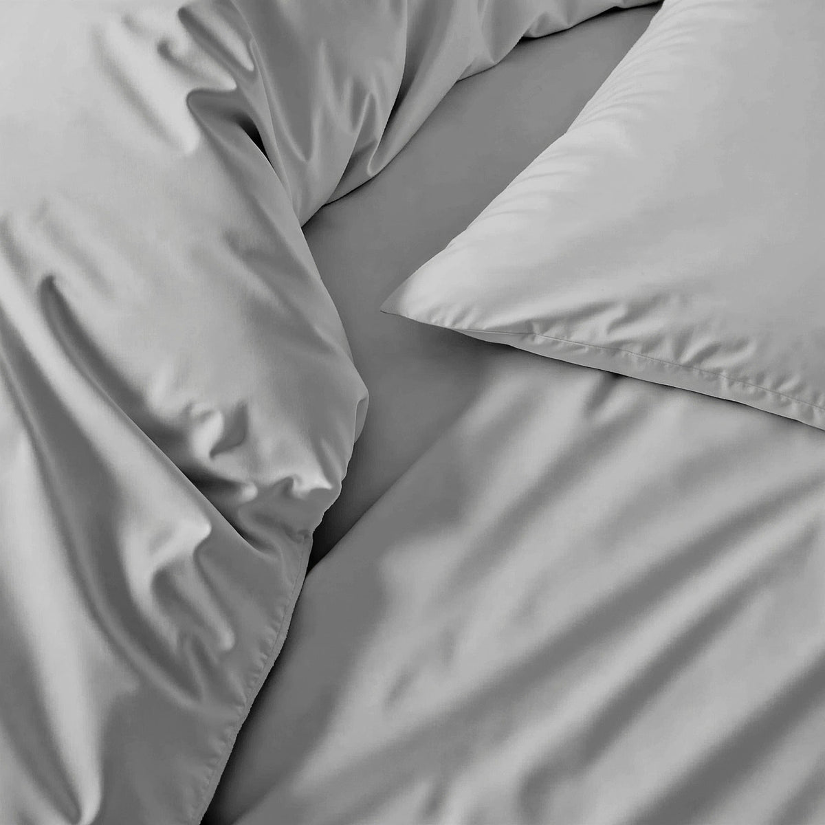 Sateen bedding set detail: smooth medium gray pillow and comforter fabric