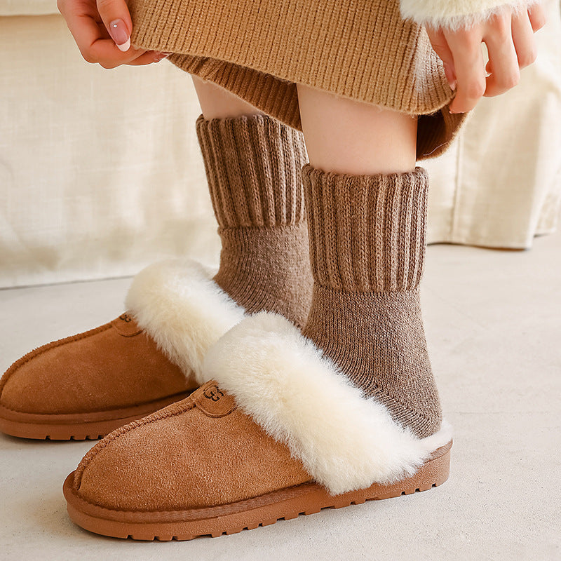 Children's thick wool tube socks in brown knit, worn with fuzzy slippers