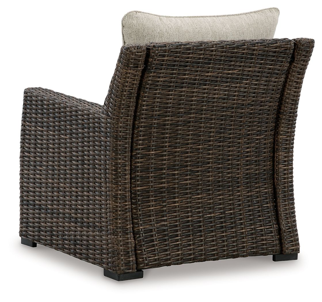 Brown woven lounge chair with beige back cushion, angled side view