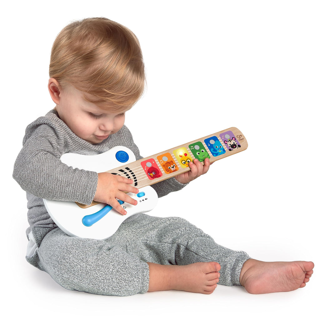 Light-up wooden guitar toy with colorful animal fretboard, held by a child