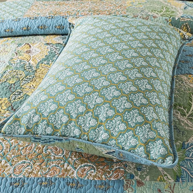 Green floral patch on quilt bedspread with blue border trim and stitched texture