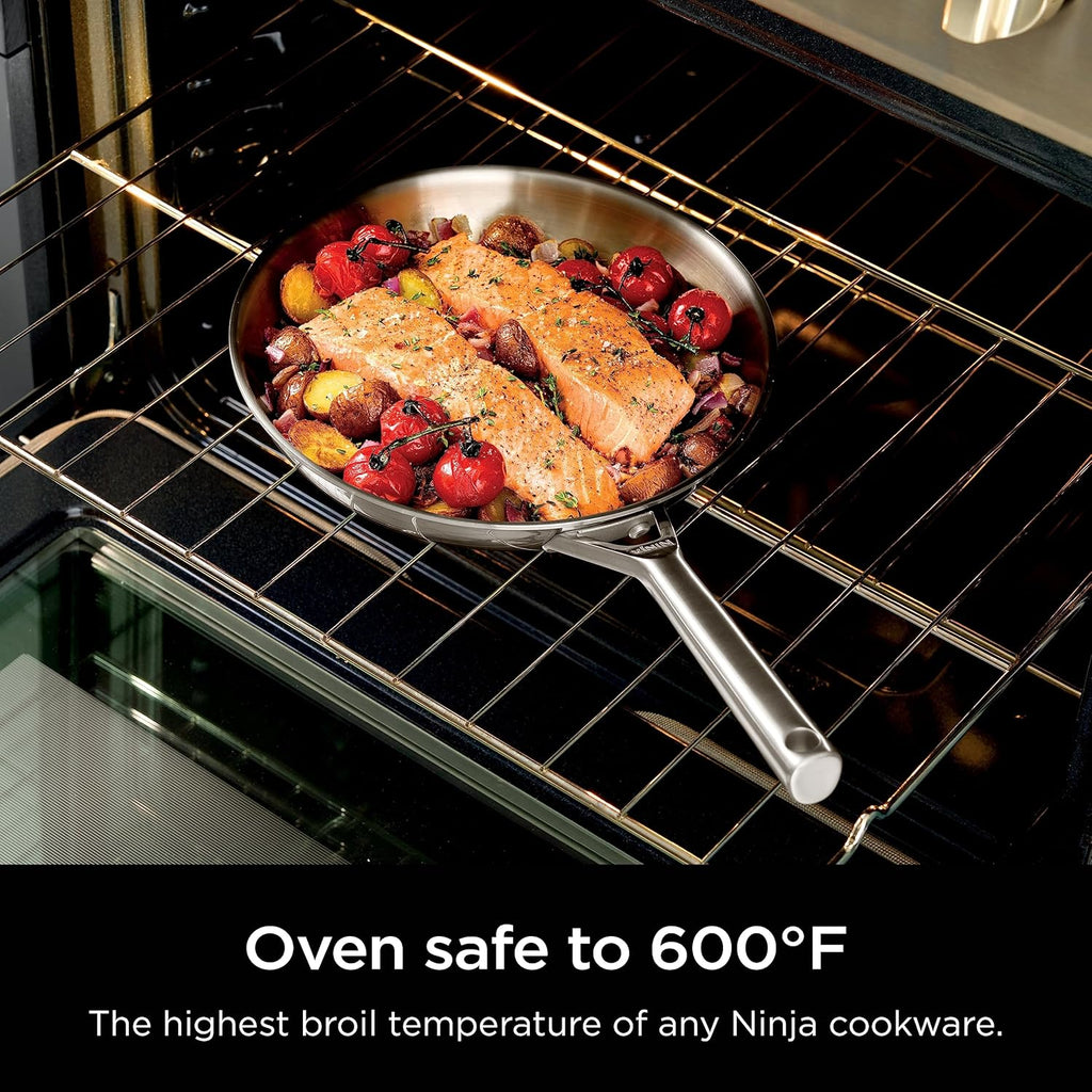 Stainless steel frying pan roasting in oven on wire rack with food inside