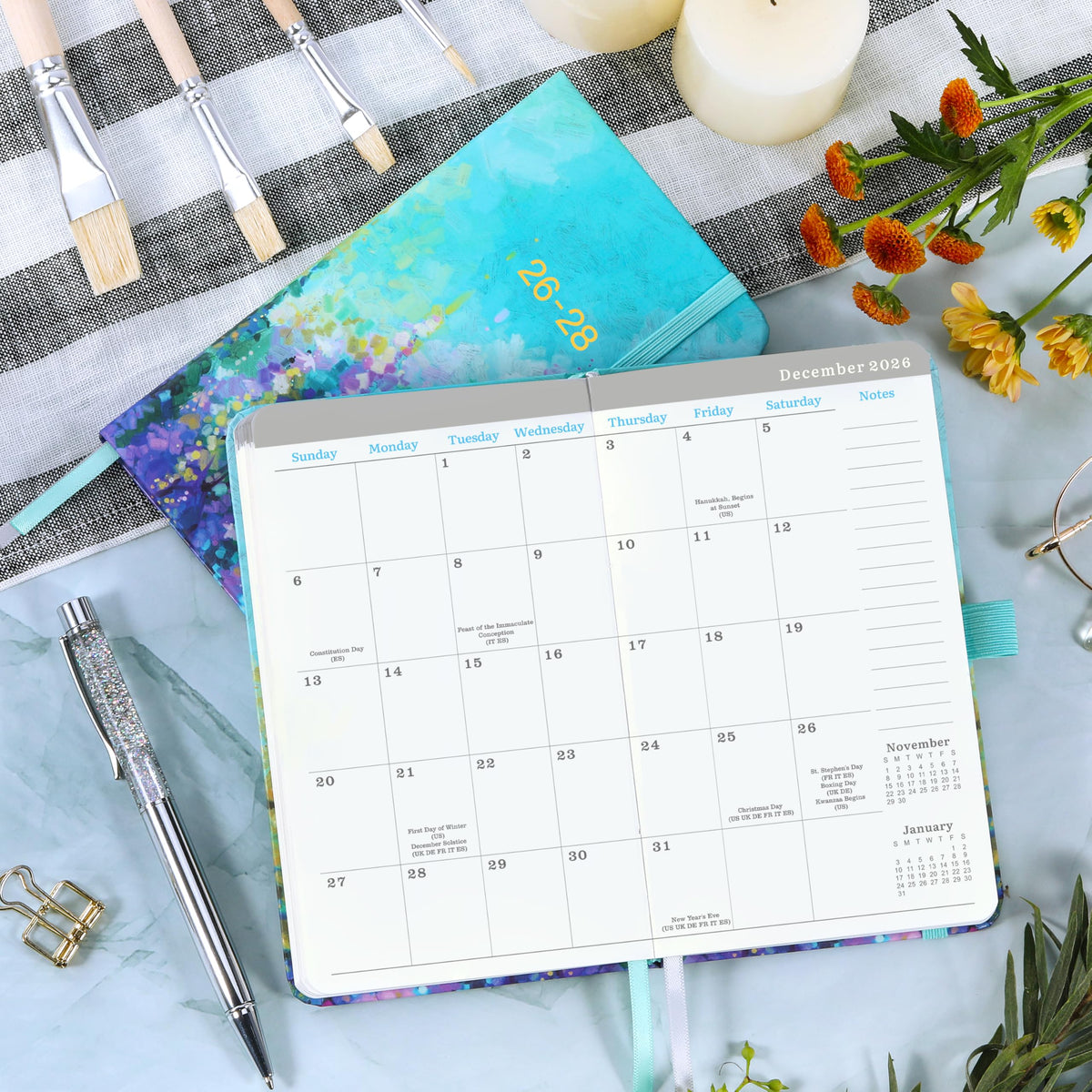 Monthly calendar spread with date grid, notes area, and teal-edged planner cover