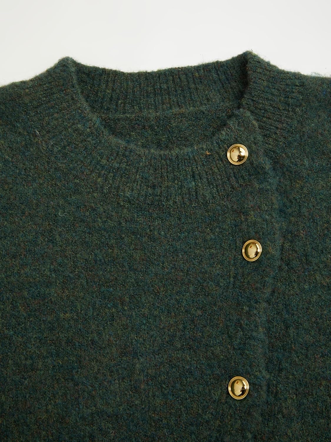 Close-up of dark green knit cardigan neckline and gold snap button placket