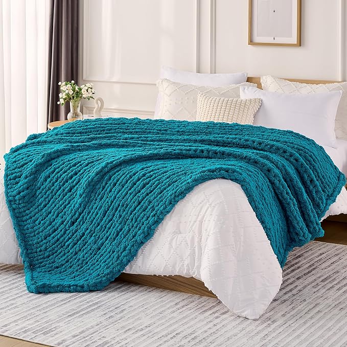 Teal chunky knit throw blanket with thick cable-style texture, draped on a couch