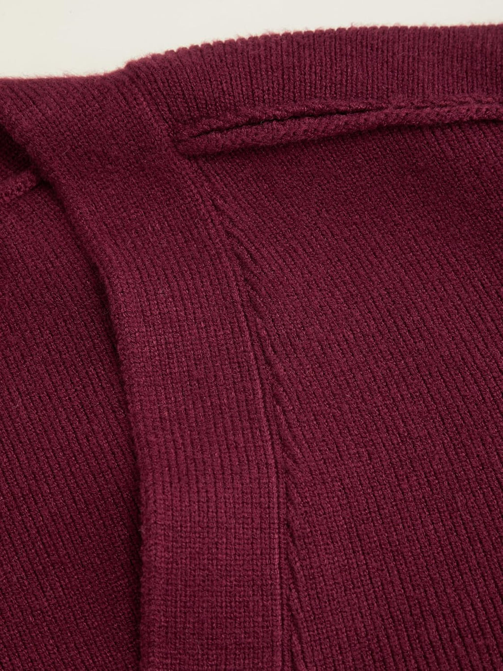 Wine red cardigan knit close-up with ribbed V-neck trim and button placket seam