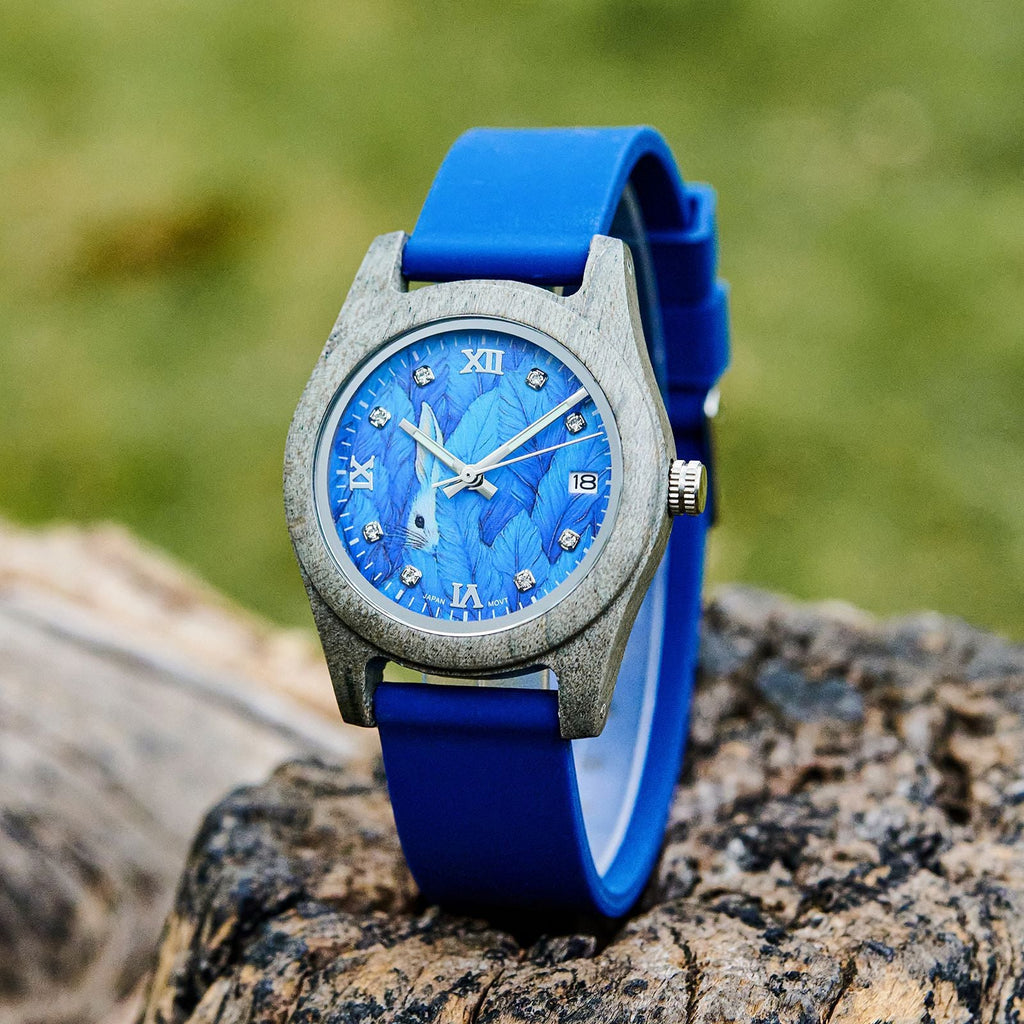 Gray wood-look wristwatch with blue roman numeral dial and blue silicone strap.