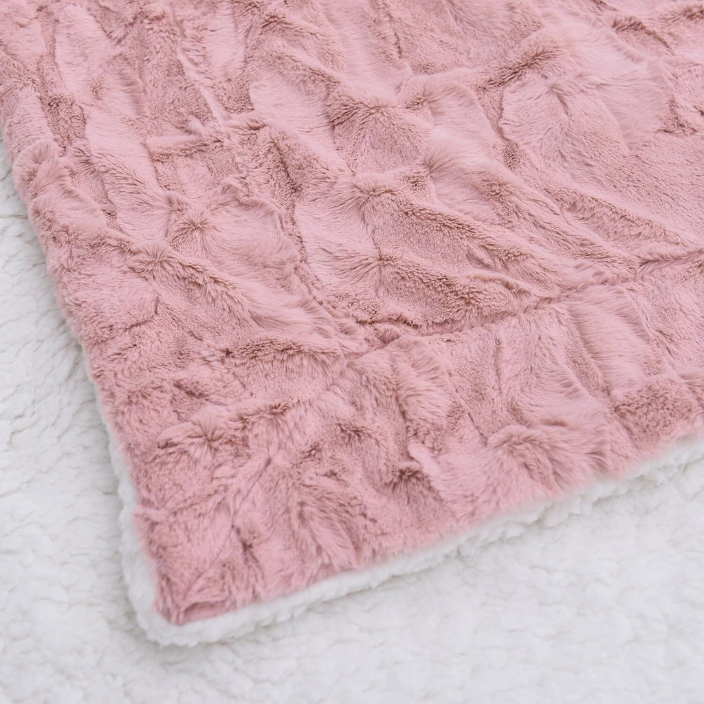 Dusty pink faux fur throw blanket with plush textured surface and white-trim border