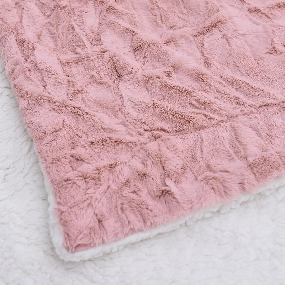 Dusty pink faux fur throw blanket with plush textured surface and white-trim border