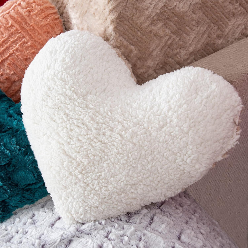 White plush heart throw pillow with thick, fuzzy sherpa-like texture