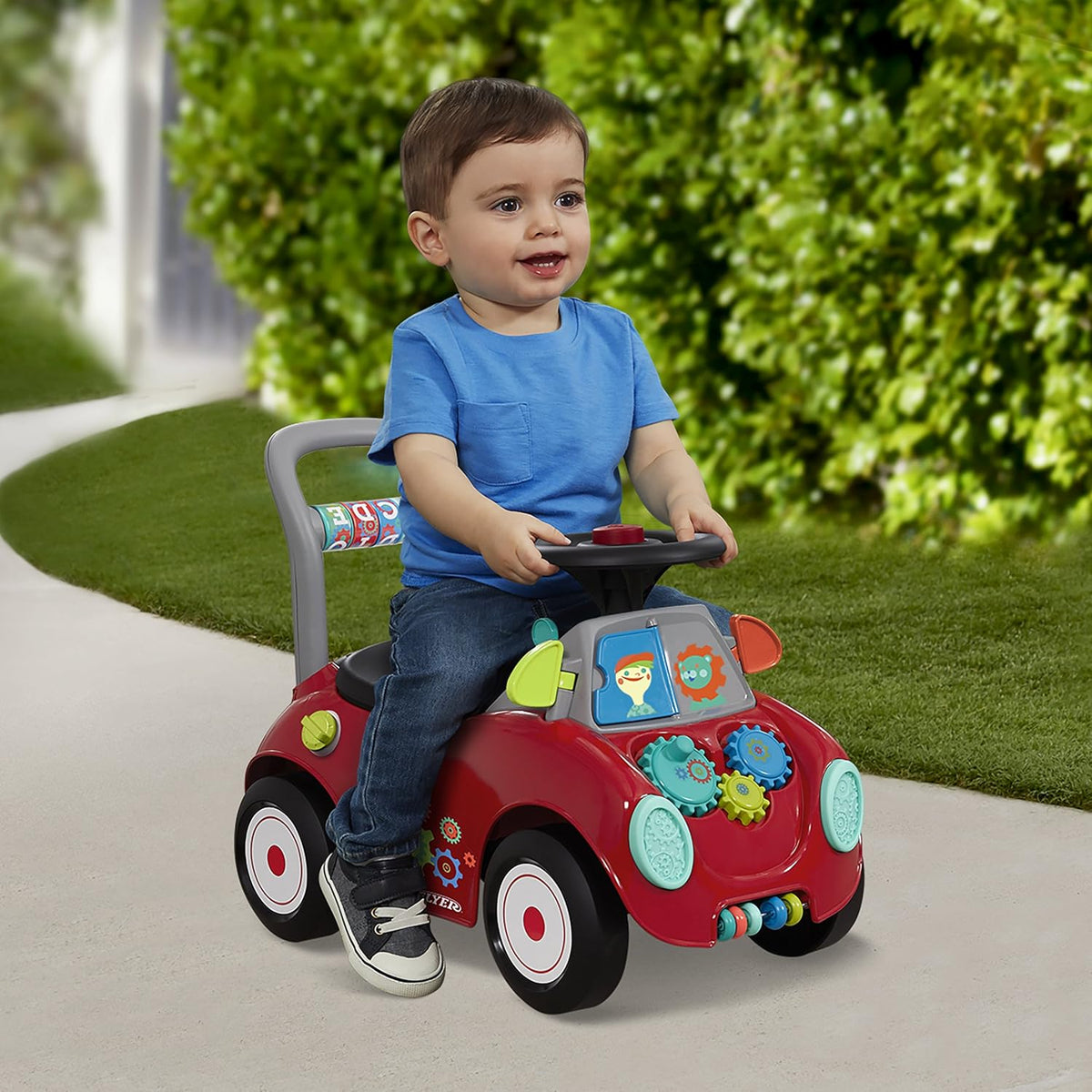 Red toddler ride-on car with front activity panel, teal headlight details, and wheels