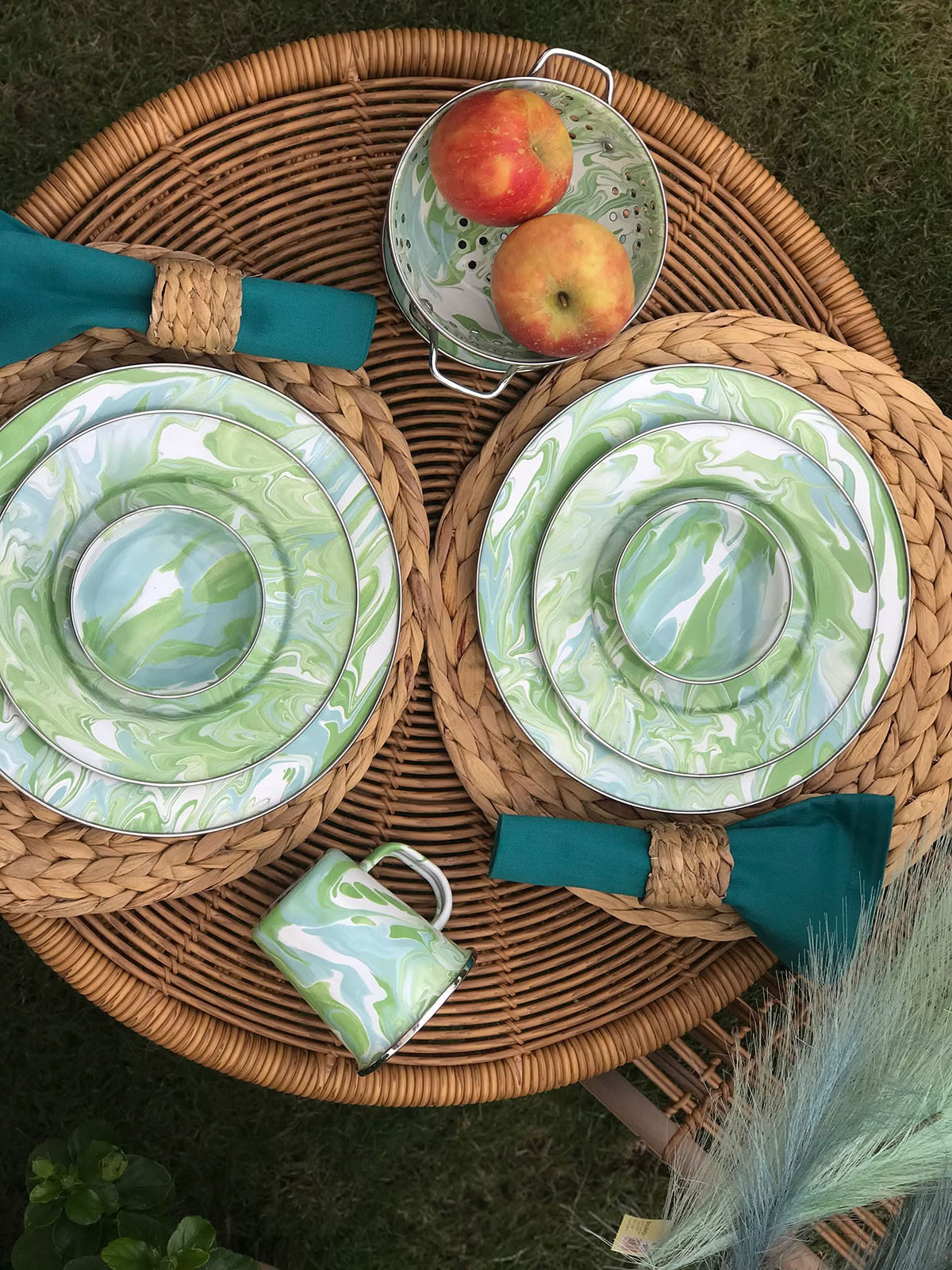 Three enamel mixing bowls with lids, green and white swirl pattern in a basket
