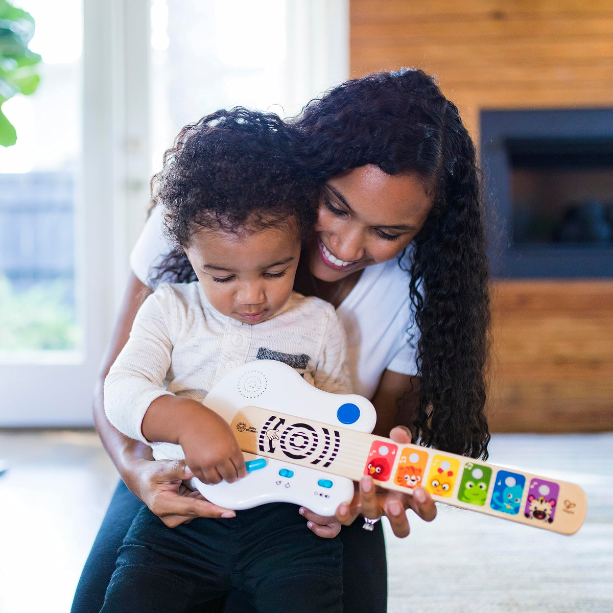 Light-up wooden guitar toy with animal fretboard and blue strum light, held with support
