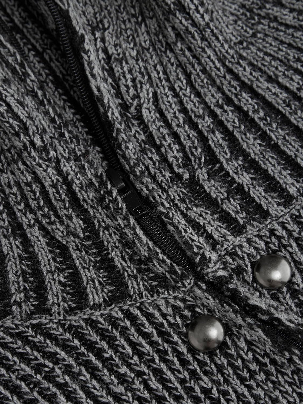 Close-up of grey textured knit fabric with dark snap buttons along placket