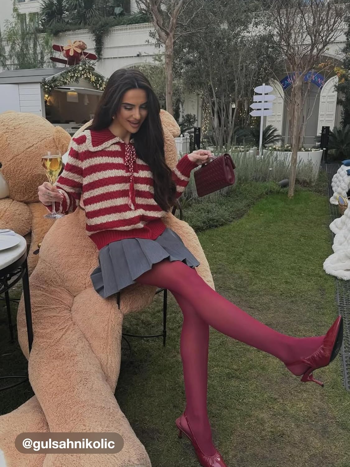Red and cream striped long-sleeve knit sweater with tassel drawstring neckline