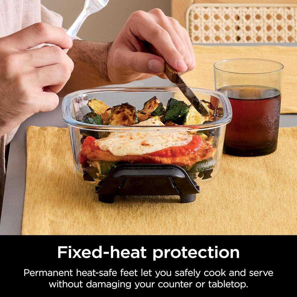 Hands serving food from a glass 6-cup container with snap-lock base and lid removed