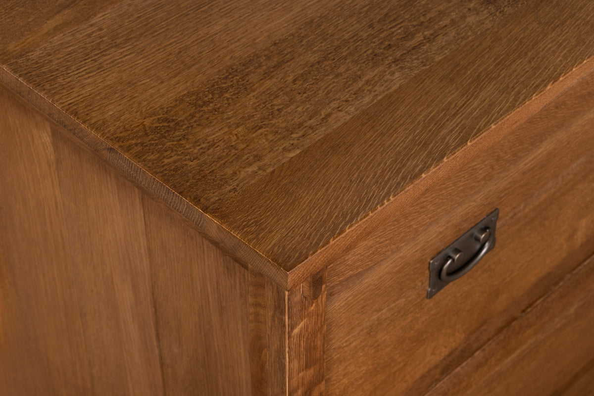 Close-up corner of walnut-stain cabinet with metal drawer pull